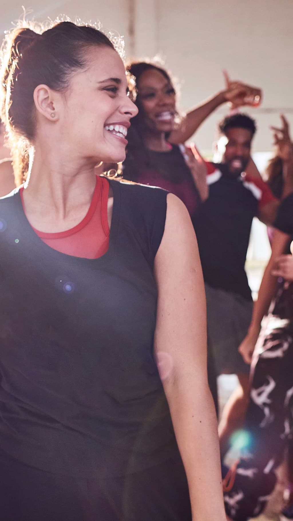 Une participante sourit au milieu d’un groupe qui danse